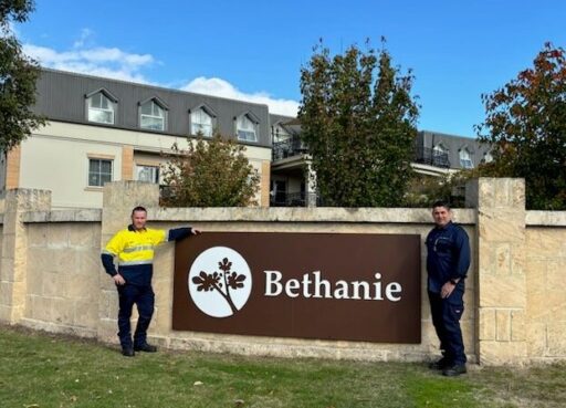 Two city workers stand outside a Bethanie Aged Care facility.